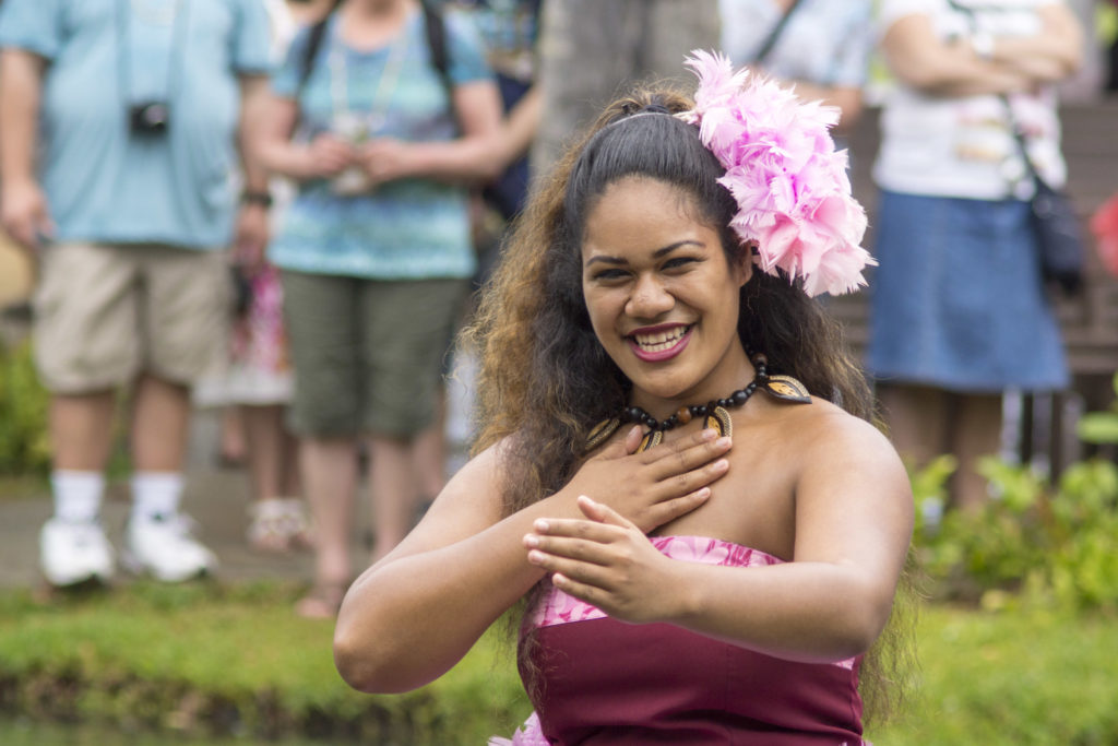 One of the dancers of the Polynesian Cultural Center dancing on a boat in the river for tourists to view.